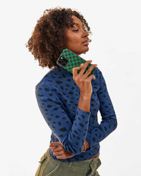 Jordan holds the Black and Green Checkers Leather iPhone Case in her right hand