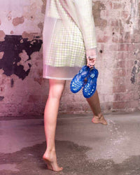 model holding the Sun Jelly Sandals in Cobalt in her right hand