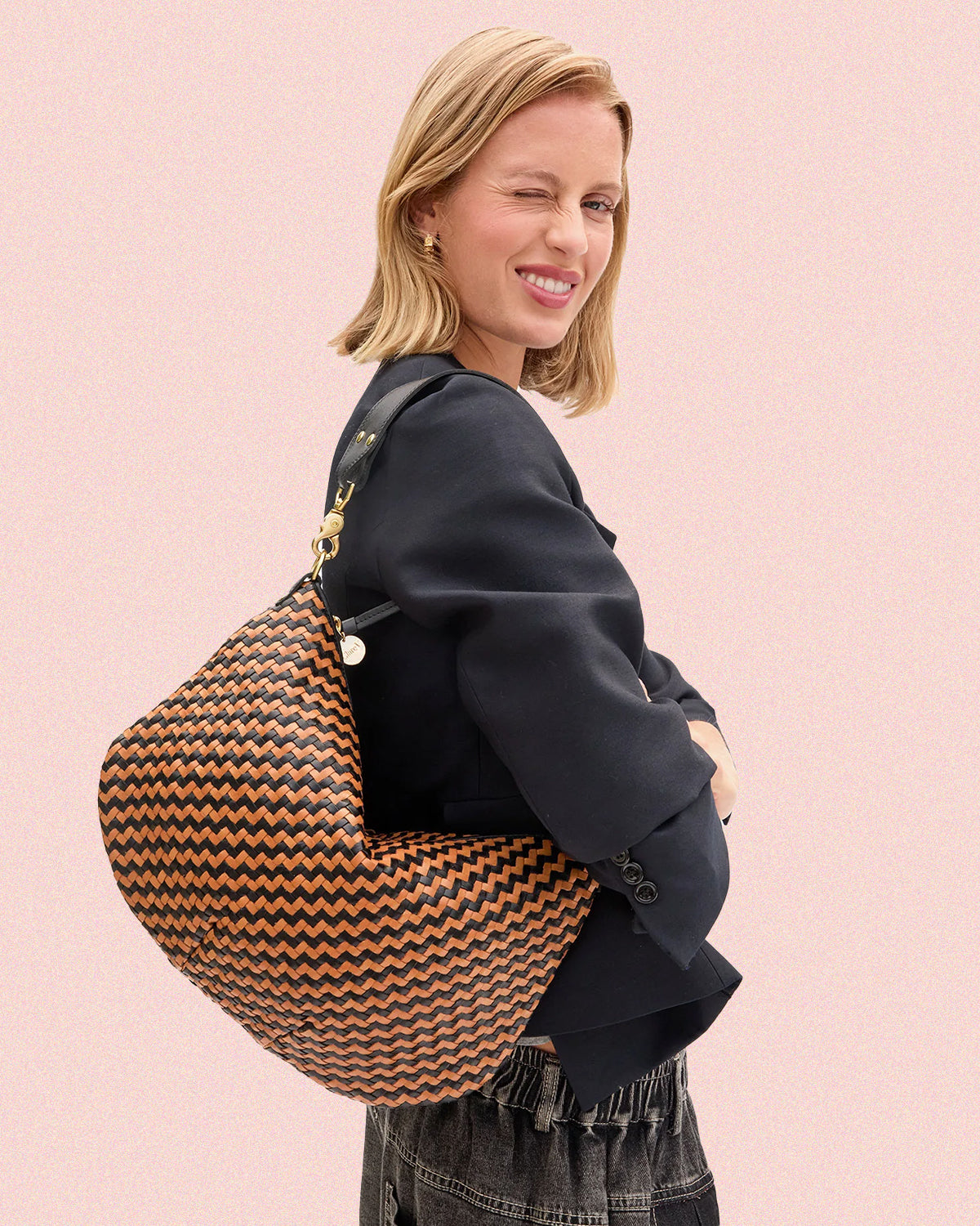 Model carrying the Black and Natural Woven Zig Zag Moyen Messenger over her shoulder. 