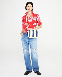 athena wearing the Indigo & Cream Woven Racing Stripes Marisol crossbody over a hawaiian shirt
