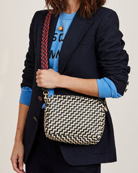 Frannie wearing the Black & Cream Woven Zig Zag Midi Sac crossbody with the red and navy braided crossbody strap