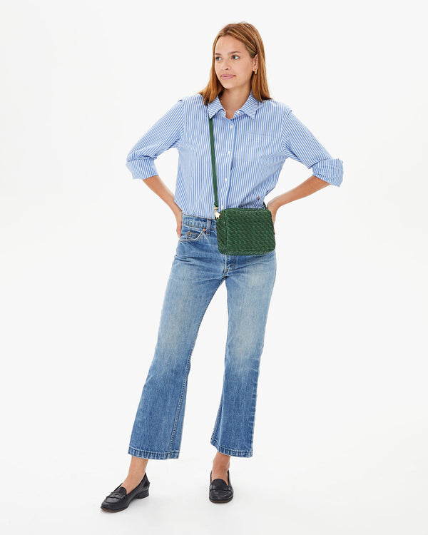 Aurelia wearing the Evergreen Woven Zig-Zag Midi Sac crossbody. she's wearing jeans a button up shirt with loafers