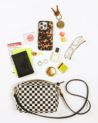 black and cream checker midi sac with an assortment of items that fit inside of it 