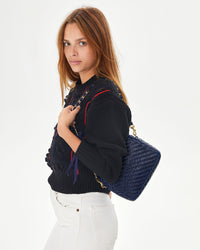 Aurelia holding the Pacific Woven Zig Zag Midi Sac on her shoulder with the grosgrain in chain shoulder strap