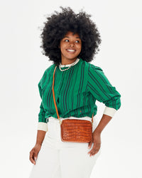 Candice wearing the Green and Black Stripe Le Tux shirt while carrying the Cuoio Autumn Croco Midi Sac as a crossbody bag.