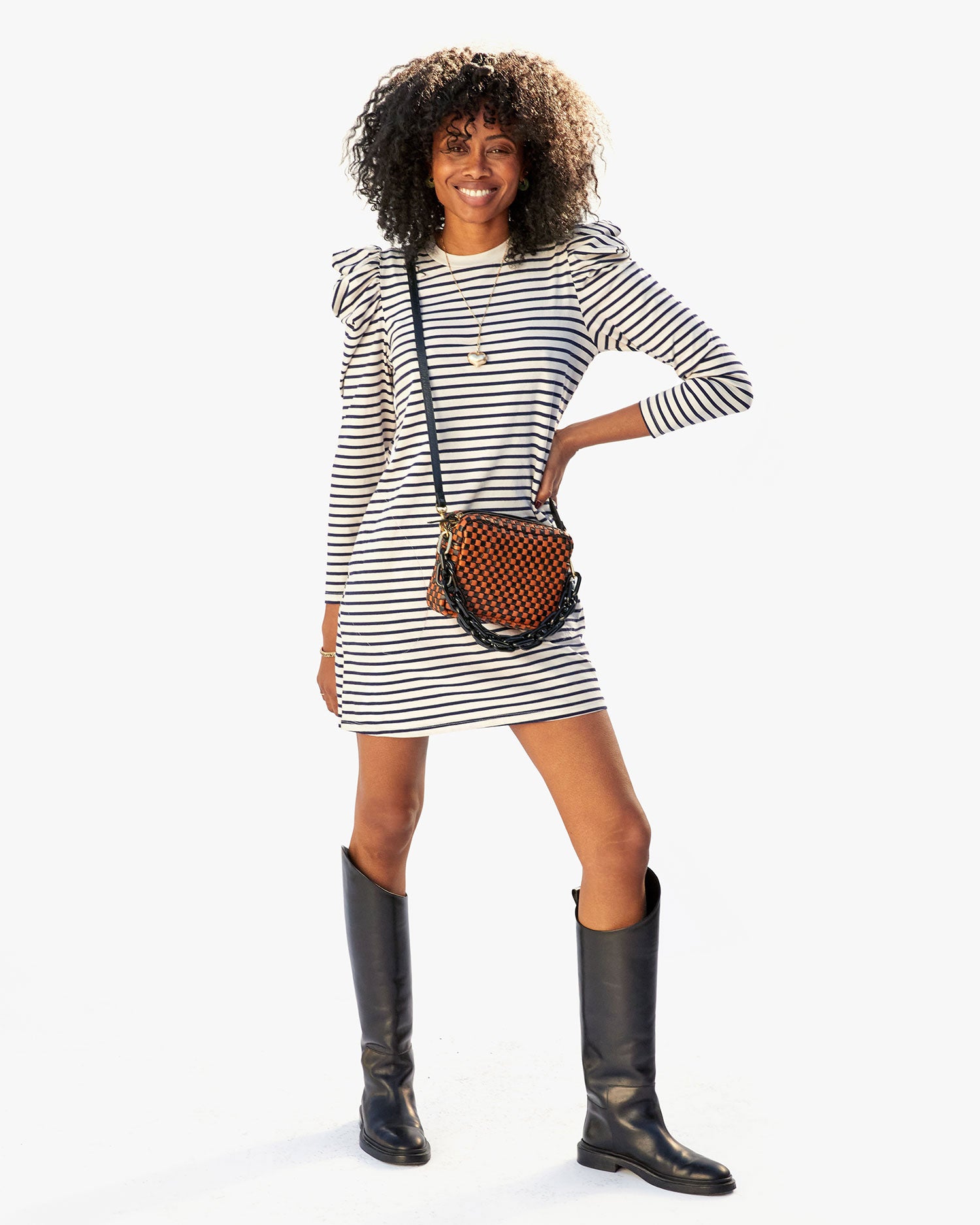 mecca wearing the black and natural checker midi sac crossbody over the Le Puff Dress in Navy & Cream Stripe