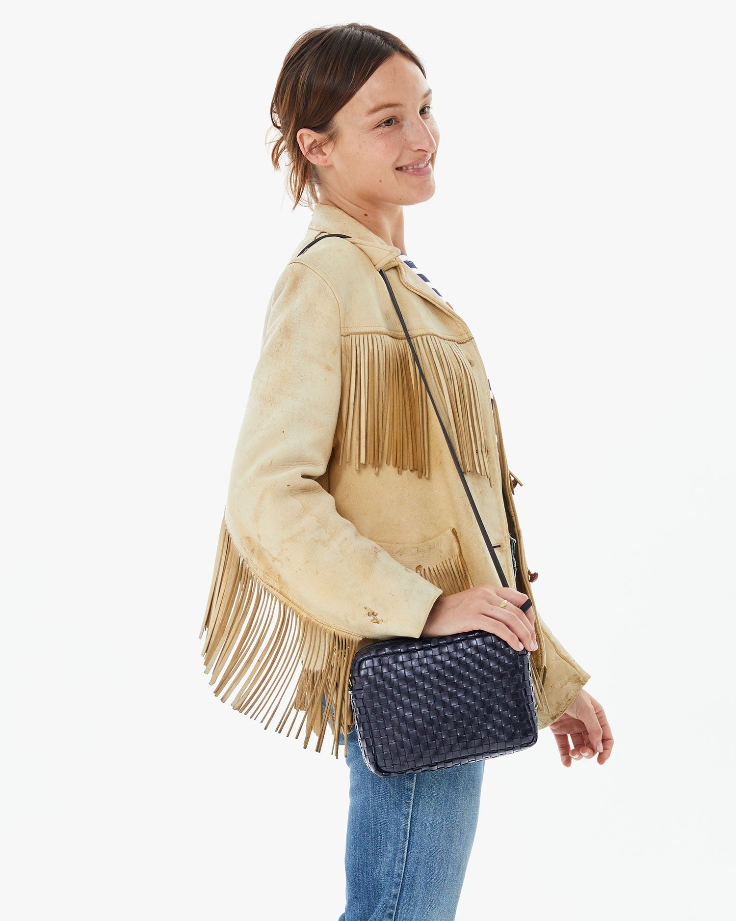 Zoe holding the Twilight Woven Checker Midi Sac on her shoulder in a fringe leather jacket