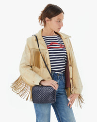 Zoe in jeans, a striped shirt and a tan fringe leather jacket with the Twilight Woven Checker Midi Sac on her right shoulder
