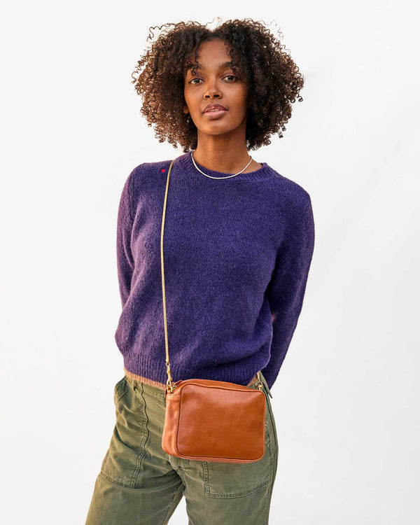 Jordan wears the Elsa sweater in Sea Urchin and wears the tan napetto midi sac as a crossbody with the gold snake chain strap
