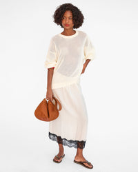 Vitoria holds the Tan Moyen Messenger by the shoulder strap in one hand