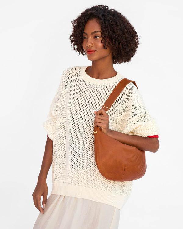 Vitoria wears the Tan Moyen Messenger on her shoulder