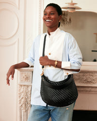 Aurelie wears the Moyen Messenger in Black Zig Zag as a crossbody
