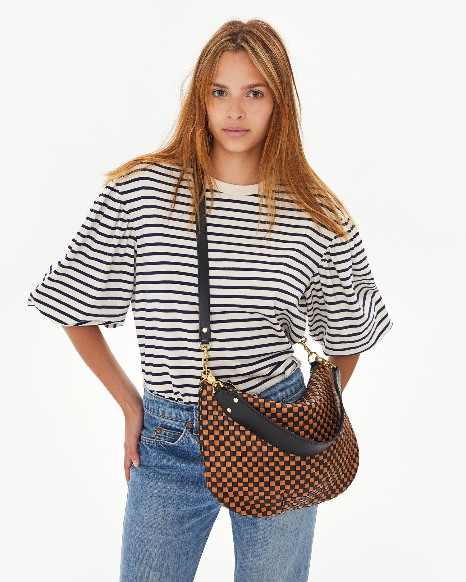 Aurelia wearing the Black & Natural Woven Checker Moyen Messenger crossbody with her hands on her hips