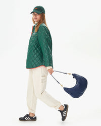 Aurelia in white carpenter pants taking a step with the Pacific Woven Zig Zag Moyen Messenger at her side
