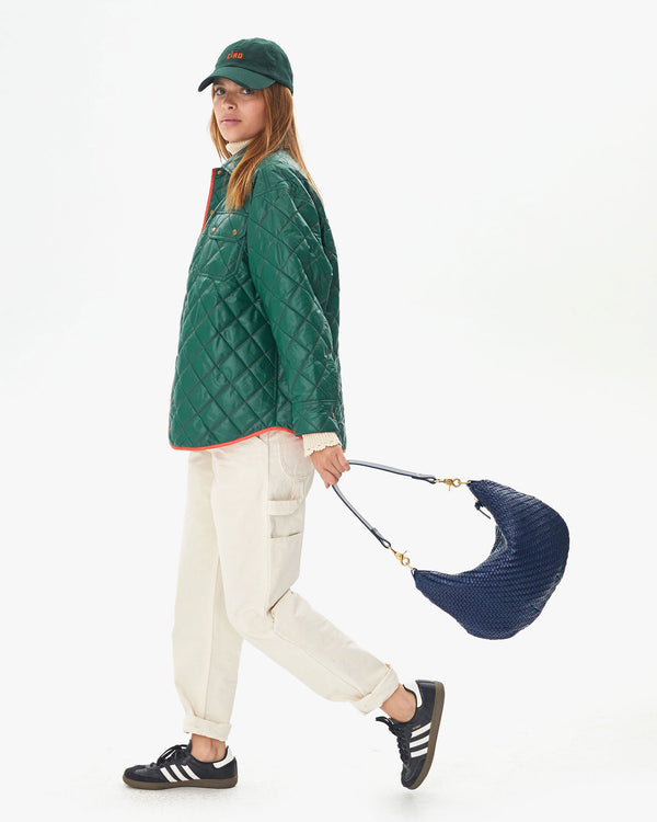 Aurelia in white carpenter pants taking a step with the Pacific Woven Zig Zag Moyen Messenger at her side