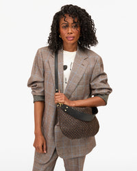 Model wearing the Black/Chocolate Woven Moyen Messenger as a crossbody bag. 