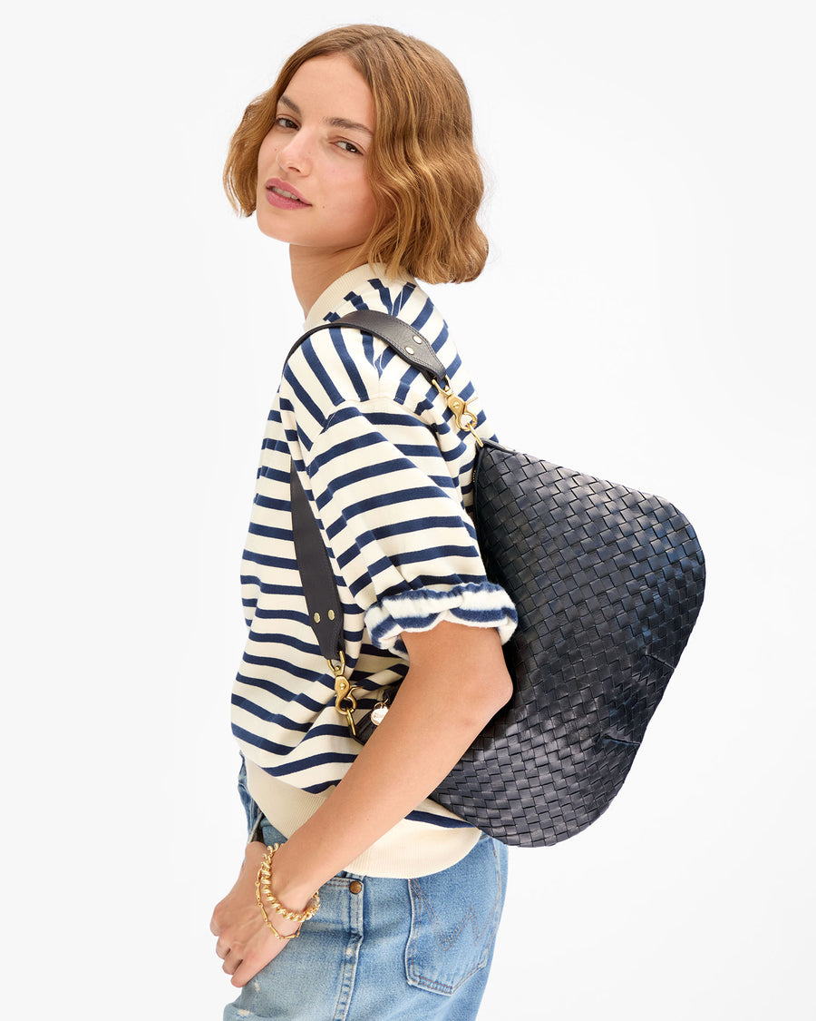 Model wearing the Navy and Cream Short Sleeve Oversized Sweatshirt with jeans and carrying the Twilight Diagonal Woven Moyen Messenger as a shoulder bag. 
