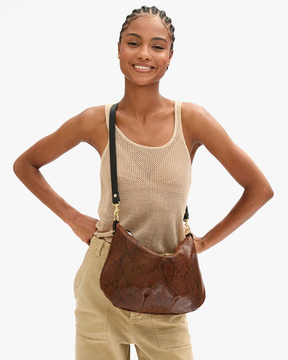Close up view of Vitoria with Moyen Messenger in Auburn Embossed Python worn as a crossbody