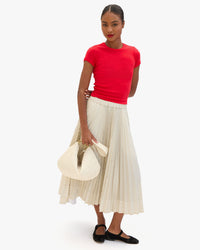 Model holding the Cream Woven Checker Moyen Messenger by the Shoulder Strap.