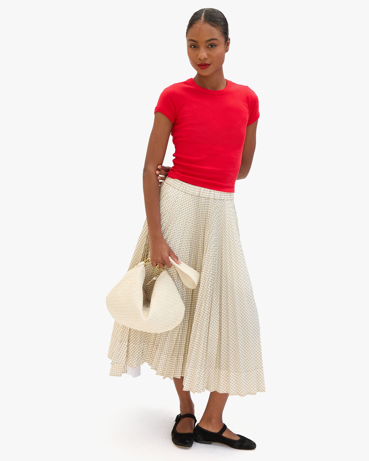 Model holding the Cream Woven Checker Moyen Messenger by the Shoulder Strap.