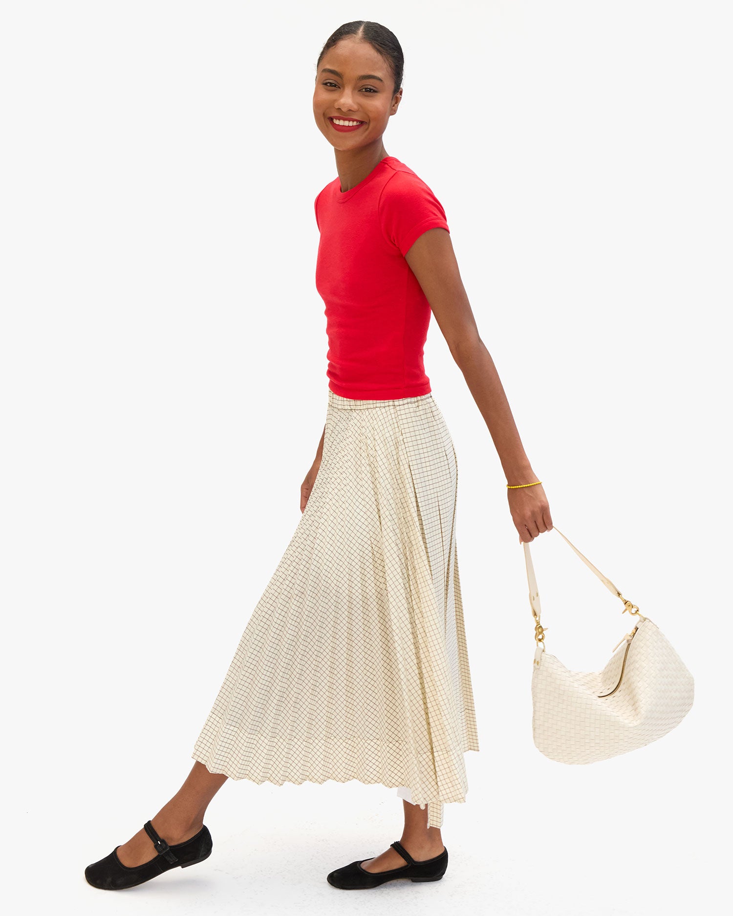 Model holding the Cream Woven Checker Moyen Messenger as a top handle bag via the Shoulder Strap. 