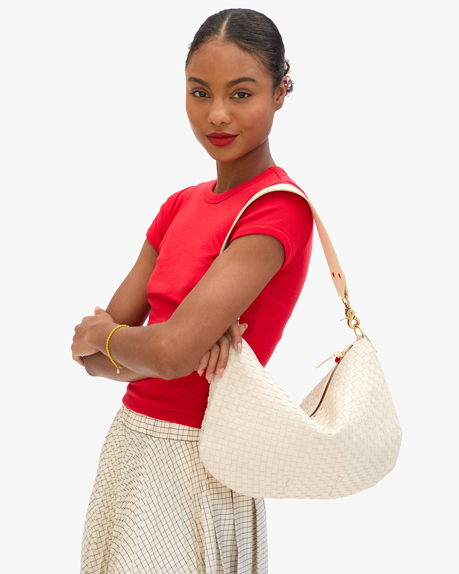 Model carrying the Cream Woven Checker Moyen Messenger as a shoulder bag.