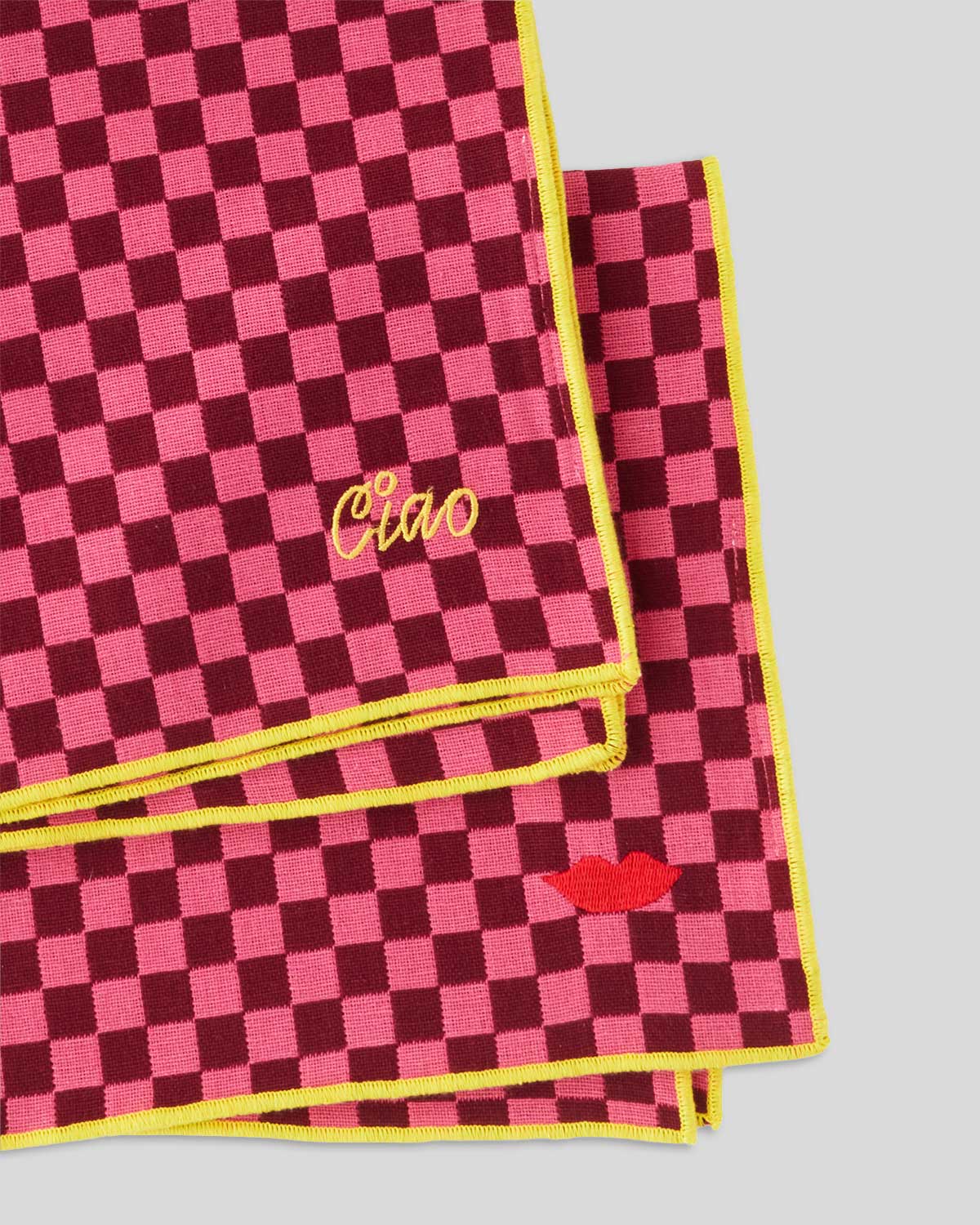 close up of the embroidery on the Neon Pink & Oxblood Checker Napkin