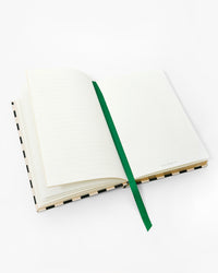 Open notebook with emerald ribbon bookmark in the middle. 