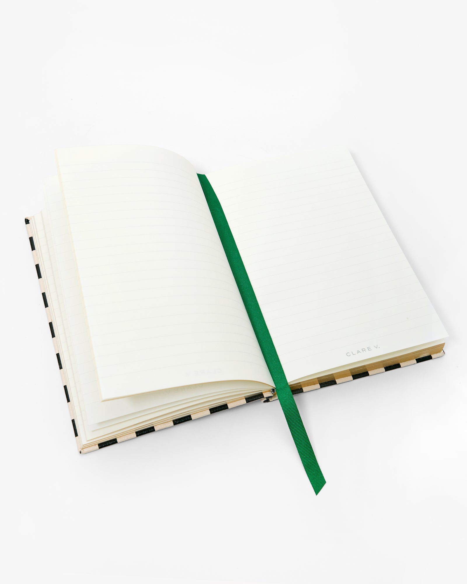 Open notebook with emerald ribbon bookmark in the middle. 