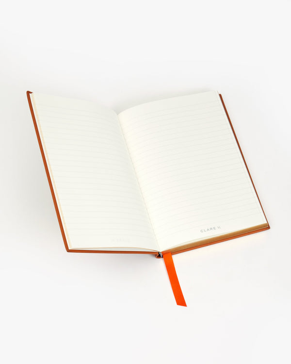 Inside of the Notebook with orange ribbon bookmark. 