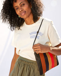 mecca in the cream bourgeoisie sauvage tee shirt with the Suede / Nappa / Rustic Patchwork Flat Clutch with Tabs on her shoulder with the thin knotted shoulder strap
