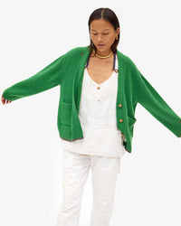 Maly in white overalls with the Oscar Sweater in Granny Smith on