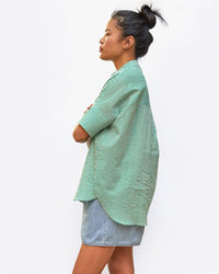 side view of sandra in the Oversized Stand Collar Shirt in Green and Cream Stripe