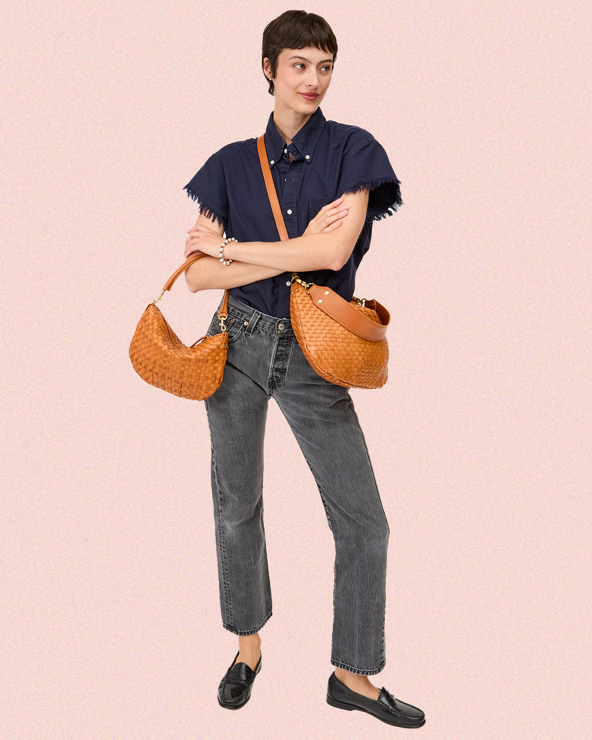 Model carrying both the Petit Moyen and Moyen Messenger in Natural Woven. 