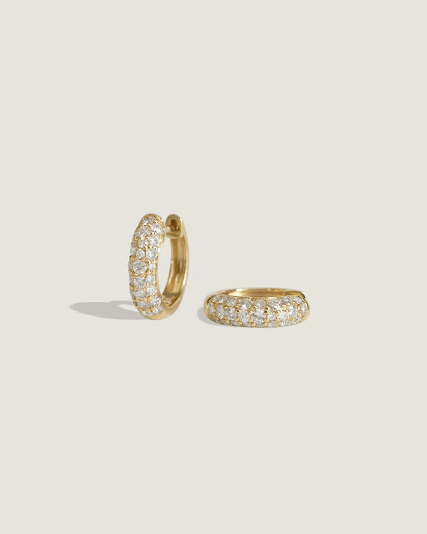 one of Kinn Studios Pavé Diamond Dome Huggies laying on its side
