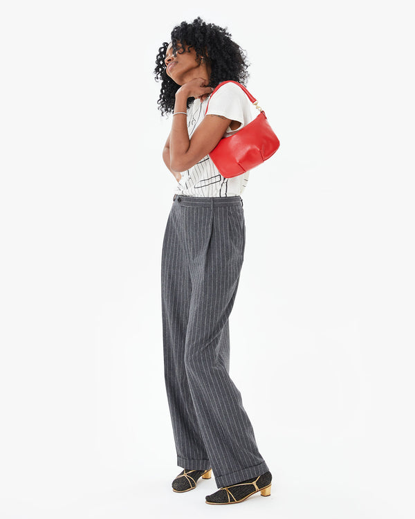 Mecca wearing the Rogue Petit Moyen on her shoulder in dress pants and a tee shirt 