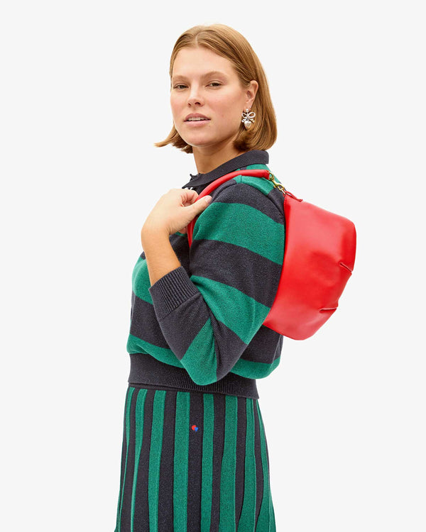 Sonnie holding the Rogue Petit Moyen on her shoulder in the Heloise Polo and Skirt