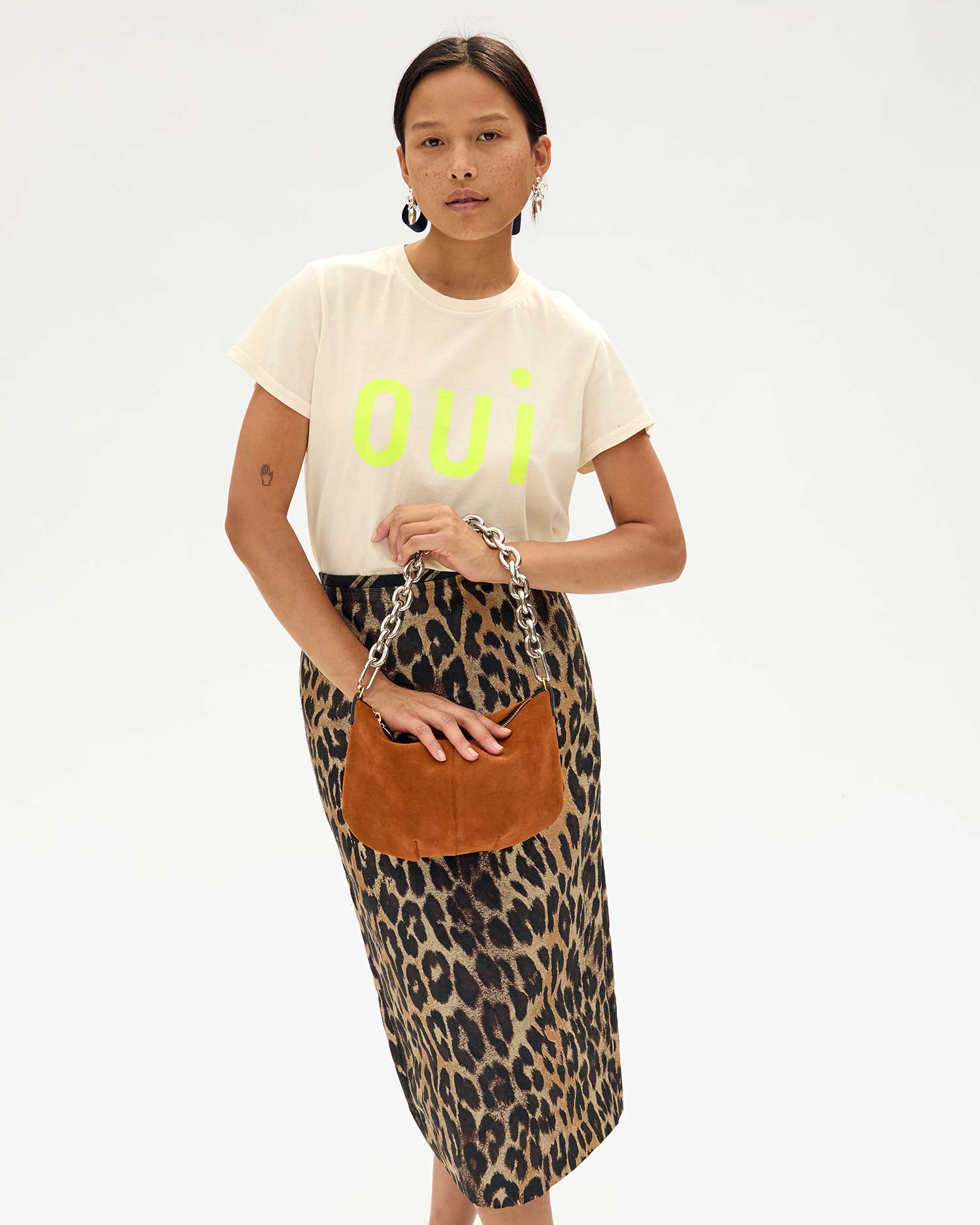 Maly in a leopard print pencil skirt with a CV tshirt holding the Chestnut Suede Petit Moyen by the silver shortie strap