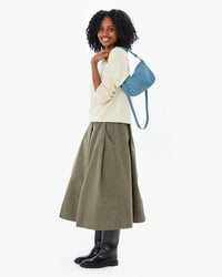 Mecca wearing the Olive Quilted Anais Midi Skirt  with the jean similaire woven checker petit moyen on her shoulder