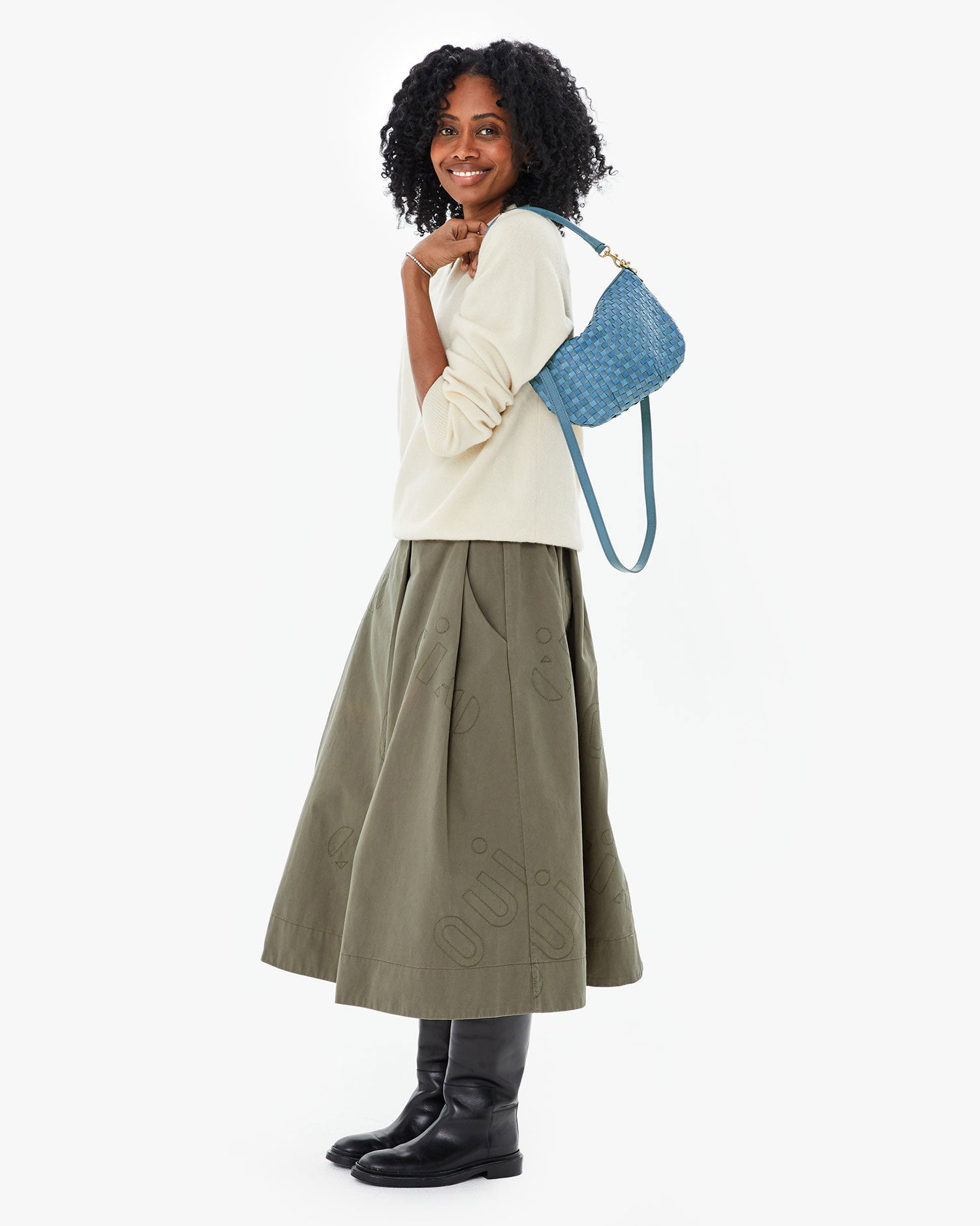 Mecca wearing the Olive Quilted Anais Midi Skirt  with the jean similaire woven checker petit moyen on her shoulder