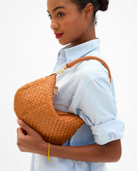 Closeup of model carrying the Natural Woven Petit Moyen as a shoulder bag. 