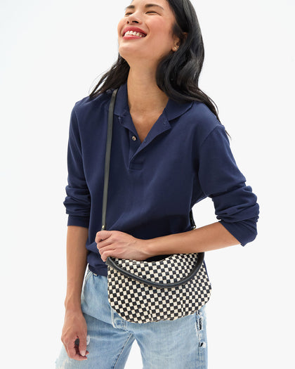 Sandra wears the Black & Cream Woven Checker Petit Moyen Messenger as a crossbody