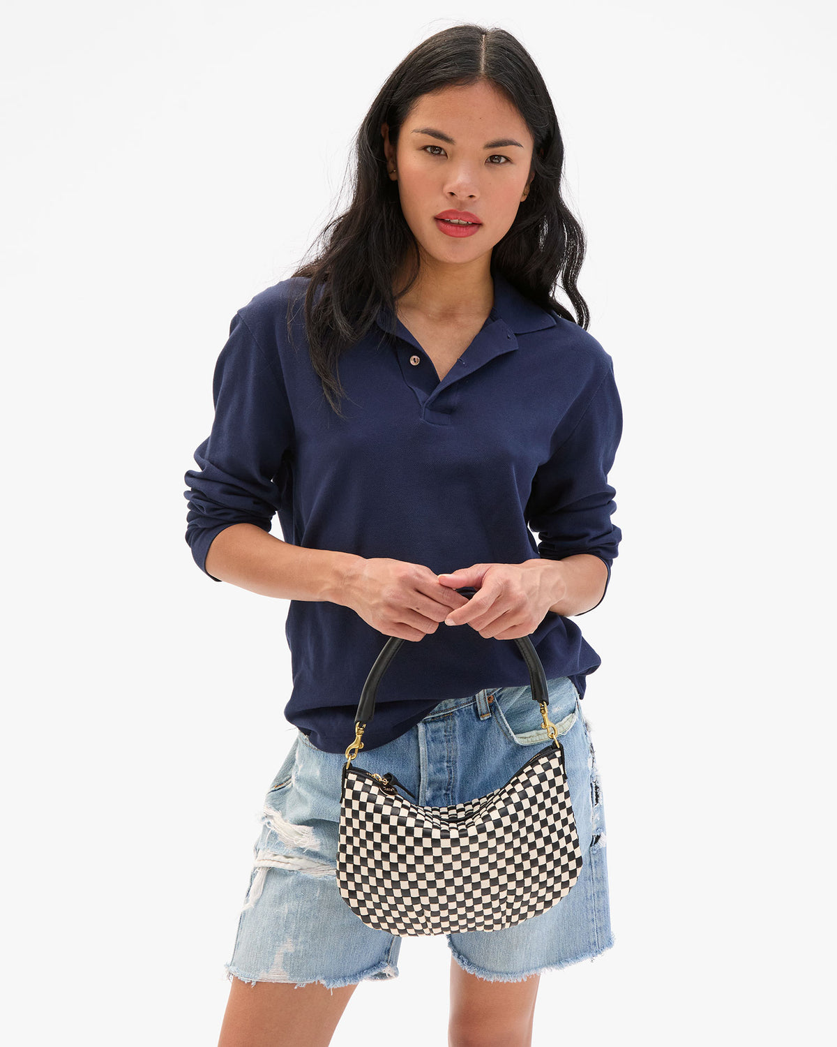 Sandra holds the Black & Cream Woven Checker Petit Moyen Messenger by the top handle