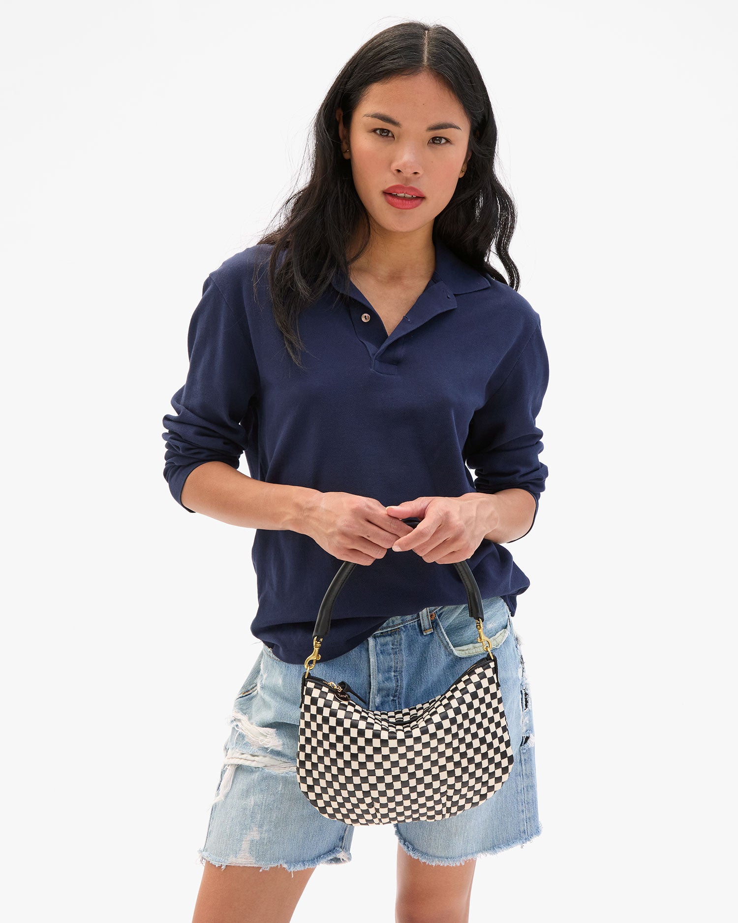 Sandra holds the Black & Cream Woven Checker Petit Moyen Messenger by the top handle