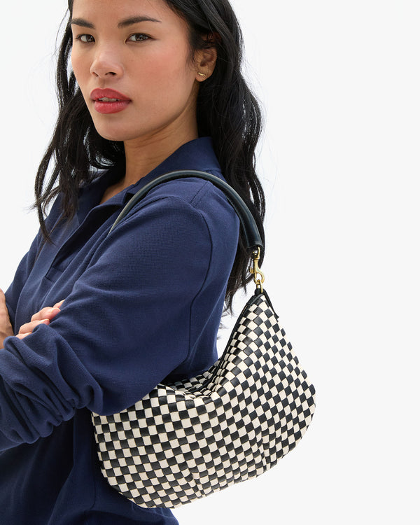 Sandra wears the Black & Cream Woven Checker Petit Moyen Messenger on her shoulder