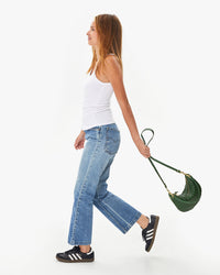Aurelia wearing jeans and a white tank top with adidas sneakers carrying the Evergreen Woven Zig-Zag Petit Moyen in her left hand