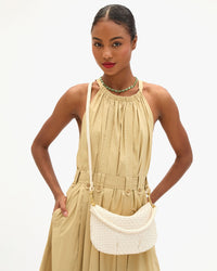 Model wearing a tan dress and carrying the Cream Woven Checker Petit Moyen as a crossbody bag.