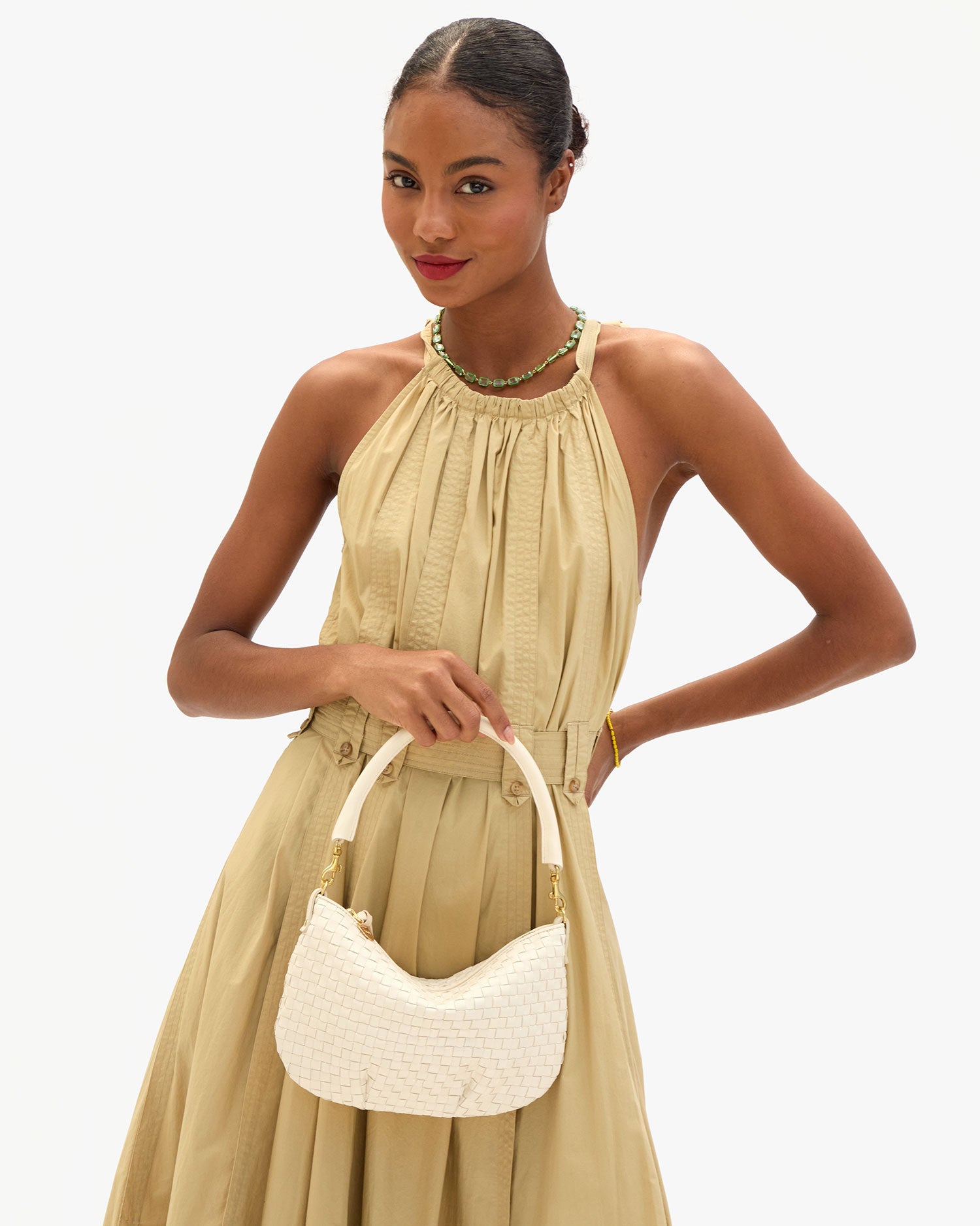 Model carrying the Cream Woven Checker Moyen Messenger as a top handle bag.