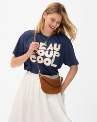 Model wearing a navy tee with 'Beau Coup Cool' text, carrying the Hazelnut Petit Moyen. 