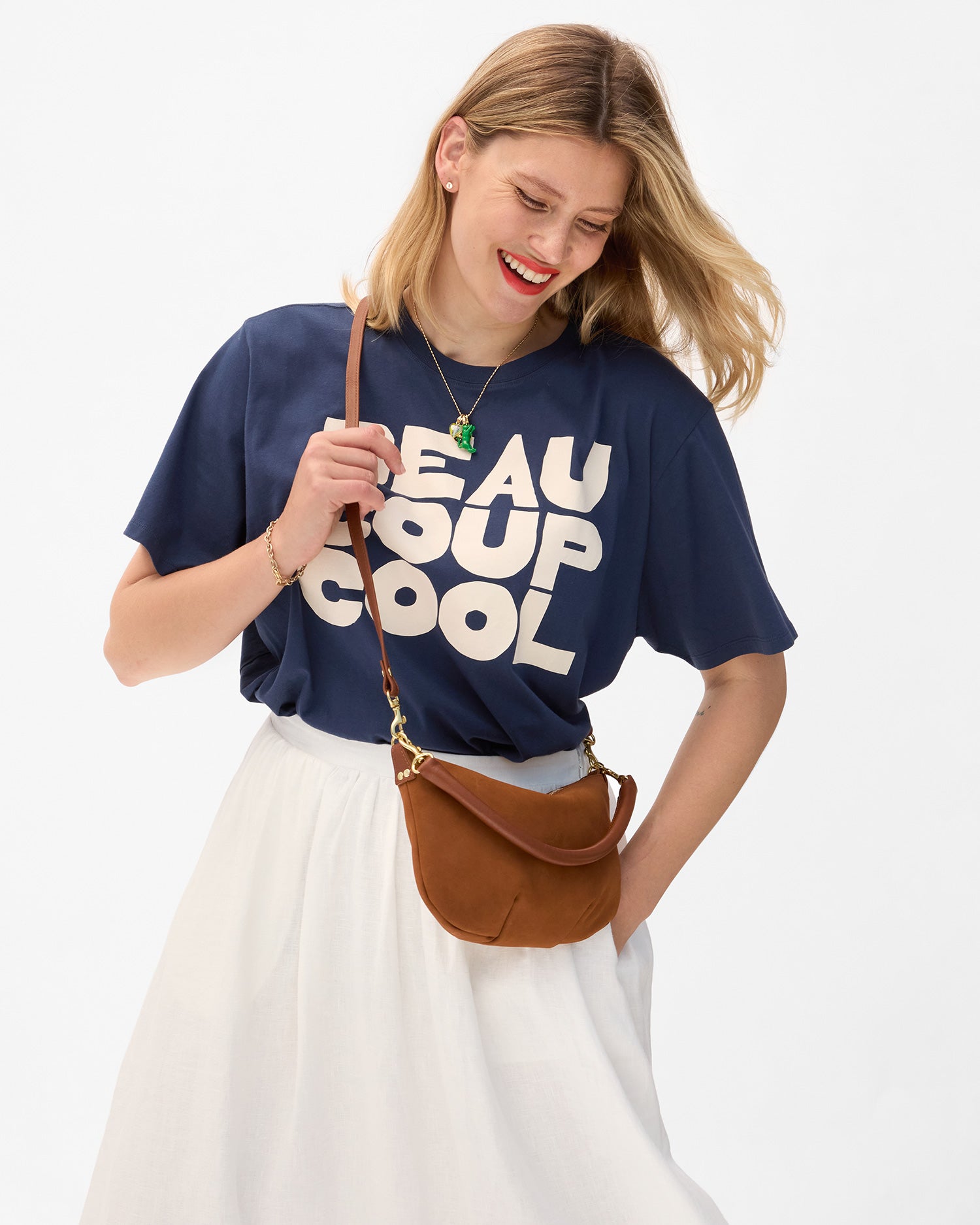 Model wearing a navy tee with 'Beau Coup Cool' text, carrying the Hazelnut Petit Moyen. 